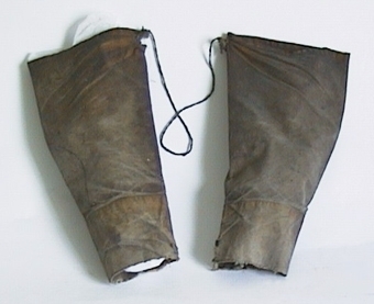 Armskydd av bomullsväv, behandlade med linolja. Består av två ärmar hopsatta med fiskgarn.