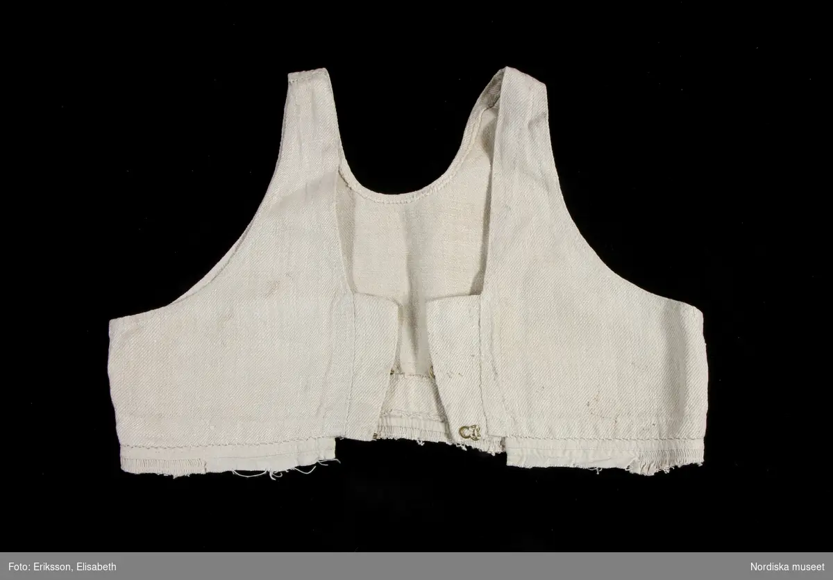 Livstycke, "bod" som varit fastsydd på en linnekjol. Av handspunnet lingarn, blångarn, i treskaftad kypert, "treskäft".  2 raka framstycken och ett ryggstycke, skarvat på axlarna, små kilar i sidsömmarna. Öppet framtill med 3 cm breda knäppkanter på båda sidorna med 2 par hakar och hyskor av mässing. Fåll nedtill med översta delen av kjolen kvar som en ring runtom, där man kan se den täta rynkningen och att kjolen varit av ett tunnare tuskaftat linne.
Denna typ av livkjol kallas i Mora och på Sollerön för vitsärk och användes sommartid. De kunde vävas mer eller mindre grova, och syddes mer eller mindre fint, släta, grovrynkade eller finrynkade och med grövre eller finare liv (bod) alltefter som man avsåg dem till grövsta vardagsbruk eller till helgdagsplagg.
Till fint hade de ofta liv av blommigt tyg men även röda eller gröna vadmalsliv förekom, de enklare hade vitt linneliv med bandgarnering. 
Vitsärkarna kom rätt tidigt ur bruk, sist var det de gamla gummorna, som nyttjade dem. Få är bevarade, ty det var vanligt att kvinnorna sveptes i dem.
Se Ella Odstedt: Folkdräkter i övre Dalarne sid 194-195.

Jfr. hel livkjol från Sollerön inv.nr 211804.
/Berit Eldvik 2007-09-21