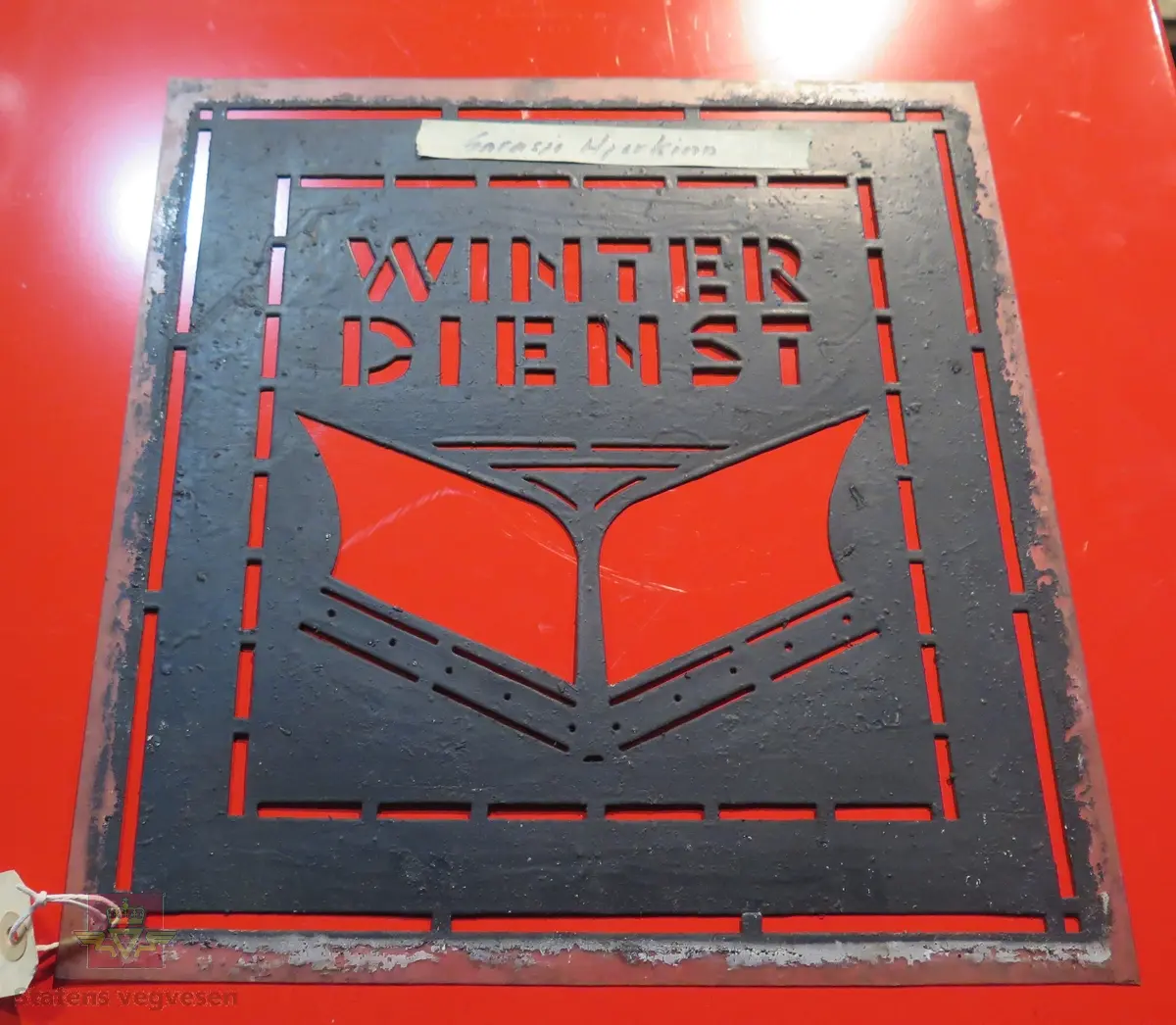 Sjablong/mal av plastlignende stoff, kanskje celluloid. Motivet viser en snøplog og teksten er "WINTER DIENST".