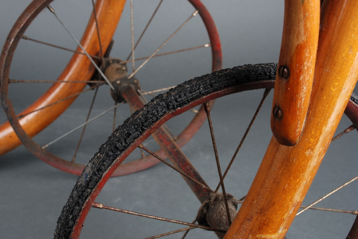 Rullestol i formpresset tre. Fotplate. Håndtak i forlengelsen av ryggen. Rotting rygg. Finert sete erstatter rotting. 2 hjul.