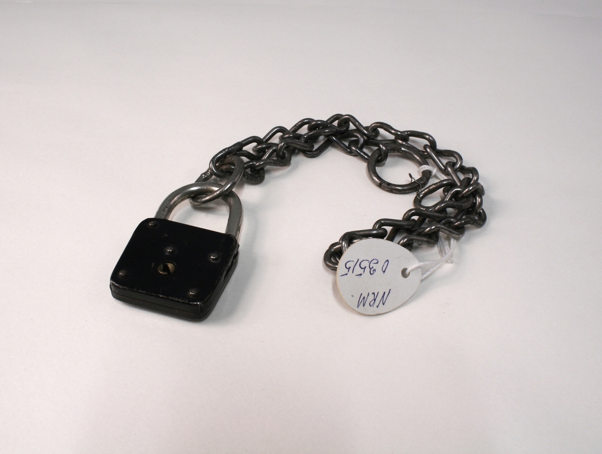 Lenke med lås. Det følger med et illustrasjonsfoto som viser hvordan jernet ble brukt og en tekst.