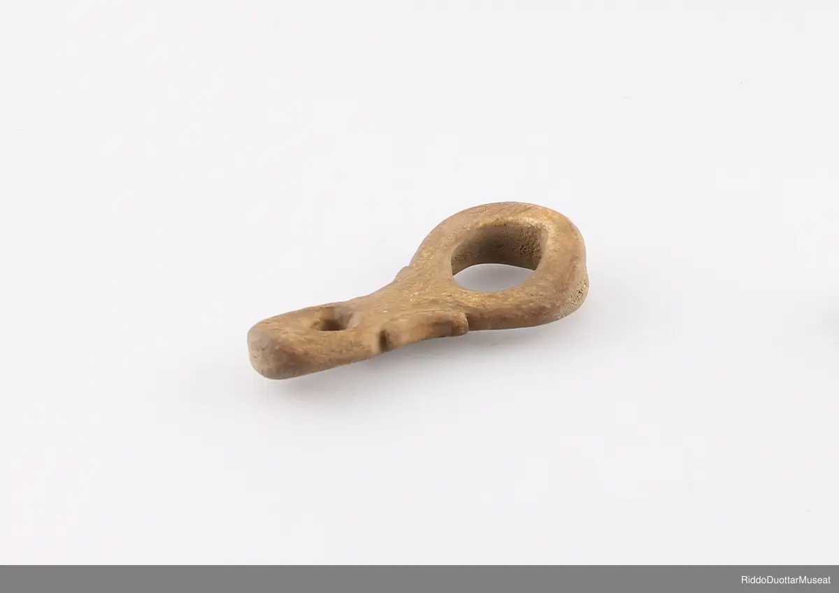 Čoarvegiella mii lea ráhkaduvvon bohcco čoarvvis, čoarvemáddagis dahje báŋis. Ravddat hervejuvvon cehkiin ja sázuin.

Lassoring av horn som er laget av reinhorn, av horn roten eller den neders delen av hornet. Kantene er dekorert med buefomede kutt og innrissede striper.