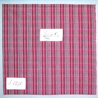 Rutigt vävprov i bomullsgarn vävt i tuskaft. Varp i lila, blått, rosa och två nyanser brunt, inslag i rött, rosa och två nyanser brunt. Provet har två påsydda tygetiketter med texten:"Lagret No 5 1929." och "T. 1276".Tygprovet är ihopfäst med ytterligare tjugoåtta prover (inv.nr 77 - 83, 85 - 100) med snören.