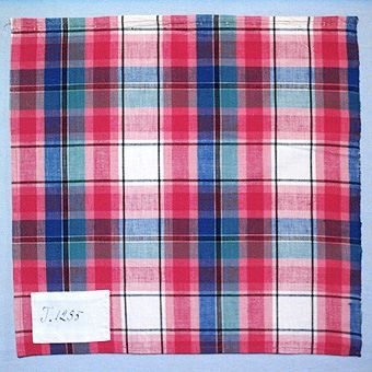 Rutigt vävprov i bomull, vävt i tuskaft. Varp och inslag i blått, rosa, rött, naturvitt, svart och turkos. Märkt med påsydd tyglapp med texten: "T. 1235". Vävprovet sitter ihopfästat med snören, med ytterligare tjugoåtta vävprover ( inv.nr 77 - 87, 89 - 100).