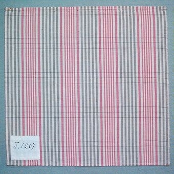 Randigt vävprov i bomull, vävt i tuskaft. Varp i naturvitt, grått och två nyanser rosa, inslag i naturvitt och grått. Märkt med påsydd tyglapp med texten: "T. 1207". Vävprovet sitter ihopfästat med snören, med ytterligare tjugoåtta vävprover ( inv.nr 77 - 94, 96 - 100).