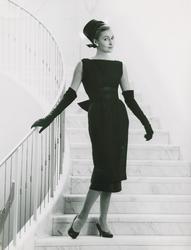 Mannekäng poserar stående i trappa, iklädd klänning, origina