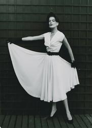 Modell i klänning med skärp, bahytt, handskar och pumps, sam