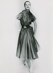 Modell i klänning med knappar och skärp, sandaletter. "Simon