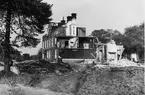 Närmast kameran syns resterna efter brukets yngsta och västligaste belägna bostadshus.
Den stora byggnaden under rivnig är det mellersta bostadshuset.