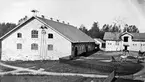 Ladugård och stall i Mackmyra, troligen 1800-talet.
Obs. hjulet på ladugårdsväggen för kraftöverföring från vattenhjulet vid smedjan till mejeriet