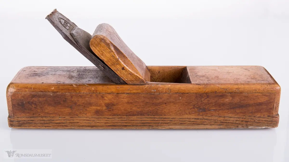 Rektangulær høvel med jern og kile. Har et spor på siden av sålen.