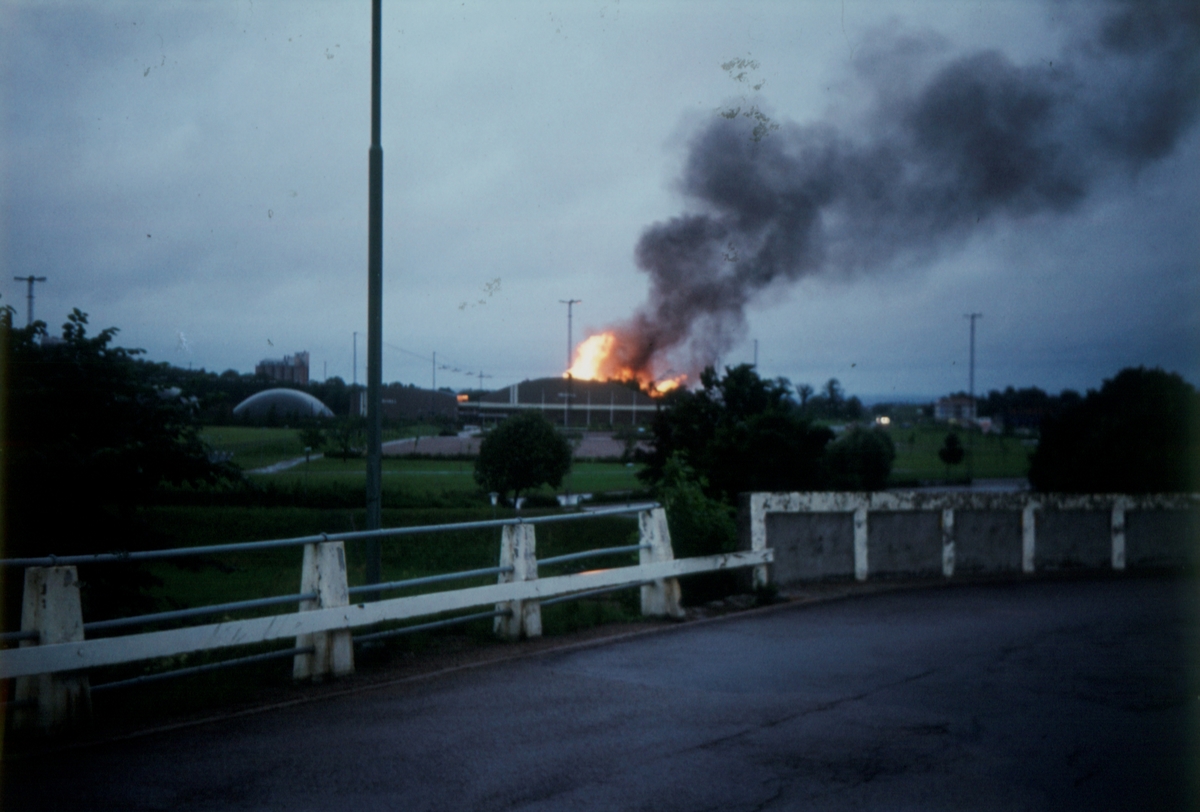 Orig. text: Tegelbruket brinner, utsikt från gamla Norrköpingsbron.

Tegelbruket ligger bakom ishallen. Kallerstad tegelbruk uppfört på 1880-talet.