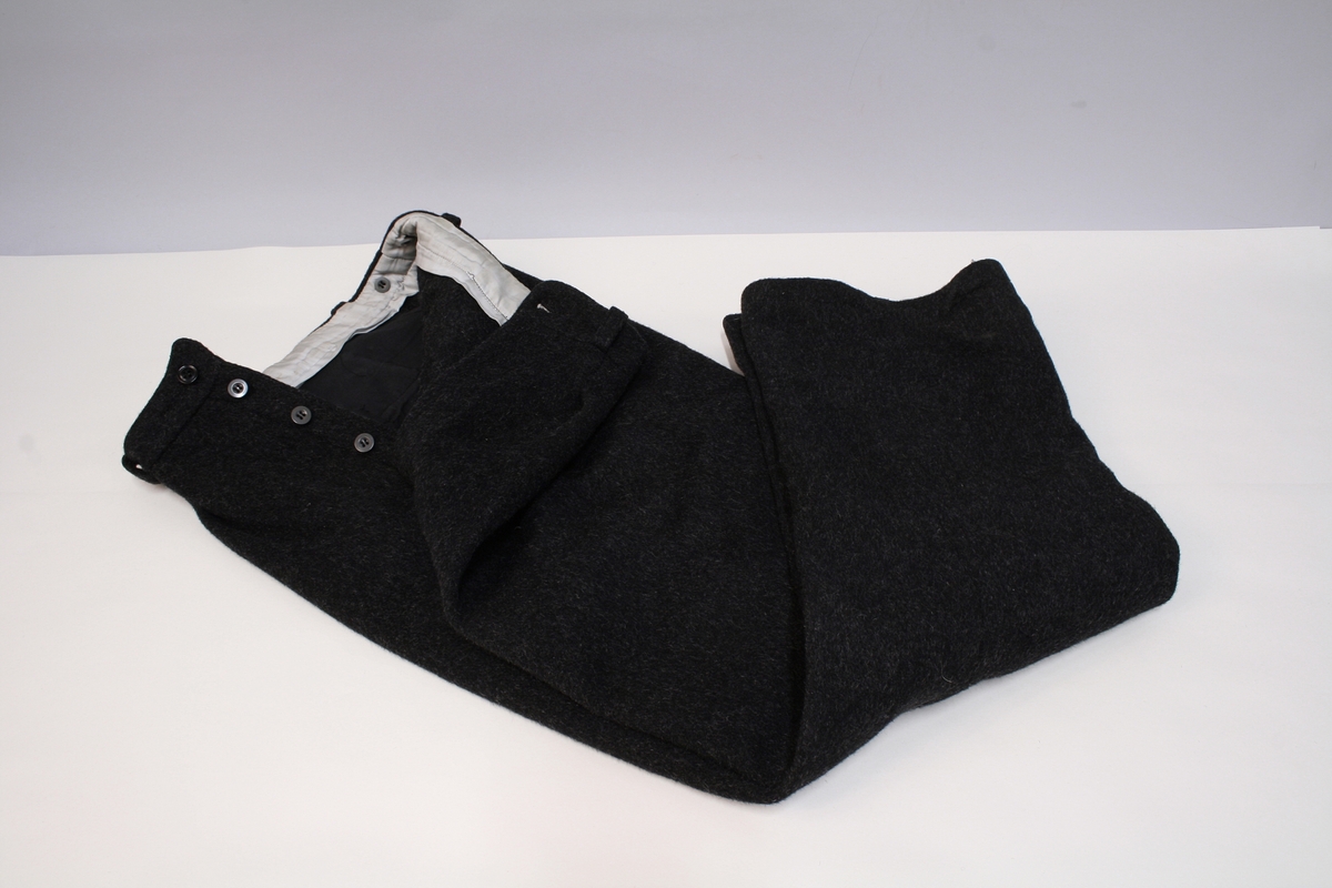 12 glatte messingknapper foran, 3 knapper på hvert av ermenes oppslag. En lomme på hver side, hver lomme med 3 knapper. Gule paspoiler om oppslag, lommeklaffer og knappingen foran.

Beltet har jernspenne med 1 torn. Devisen er fastnaglet. Man kjenner også til fra gamle tegninger av vekteren at beltet har hatt devisen "Ædru og Troe".


Har øreklaffer til å brette ned og kneppe sammen under haken. Foran en rett oppstående skygge.