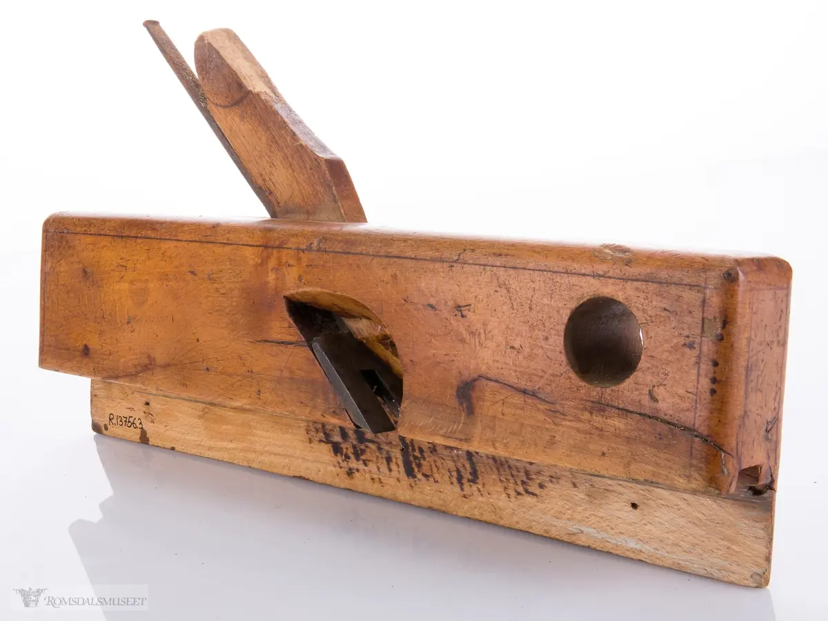Smal høvel med hesteskoformet jern for høvling av fjær. Den ene siden av høvelen har en støtteskinne.