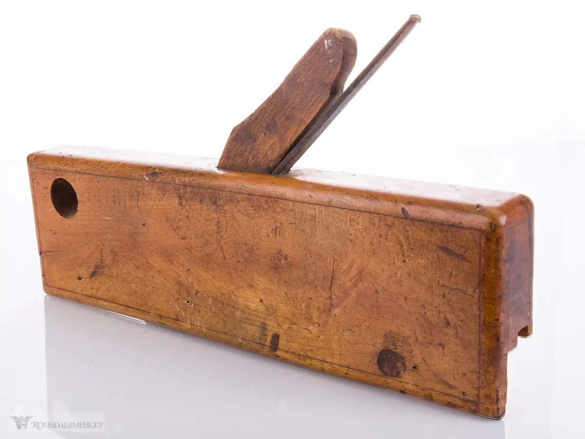 Smal høvel med hesteskoformet jern for høvling av fjær. Den ene siden av høvelen har en støtteskinne.