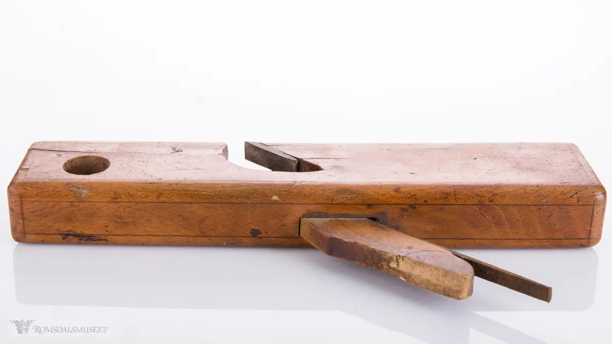 Smal høvel med hesteskoformet jern for høvling av fjær. Den ene siden av høvelen har en støtteskinne.