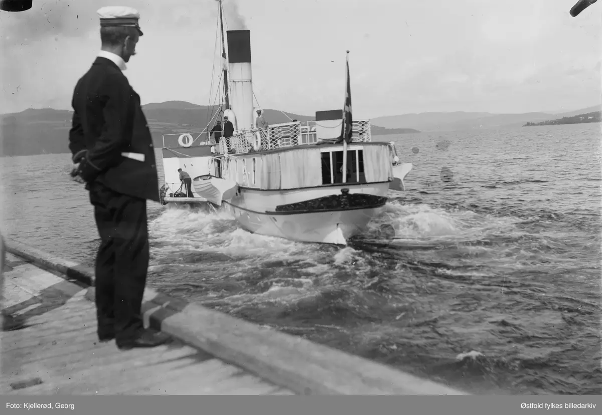 Skibladner ved Gjøvik brygge. Uniformert mann på brygga.