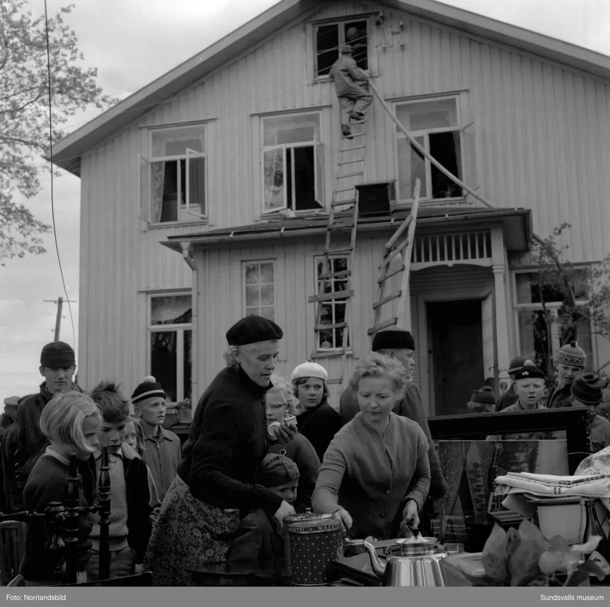 En stor serie bilder från en eldsvåda i kontorsbyggnaden och Bylanders Café vid Luckstaverken, Lucksta ångsåg. Släckningsarbete pågår och massor av människor hjälps åt att rädda så mycket lösöre som möjligt. Elden startade i på övervåningen i kassören Sven Perssons bostadslägenhet. Persson räddade sig ut genom att hoppa från balkongen på baksidan. Brandkårerna från Attmar, Tuna och Sundsvall lyckades till slut få bukt med elden men övervåningen totalskadades och det kafé som fanns inrymt i bottenvåningen fick stora brand- och vattenskador.