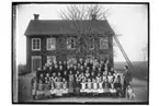 Lännäs skola, tvåvånings skolbyggnad, 61 skolbarn och lärare med hund.
Organist R. Wallin