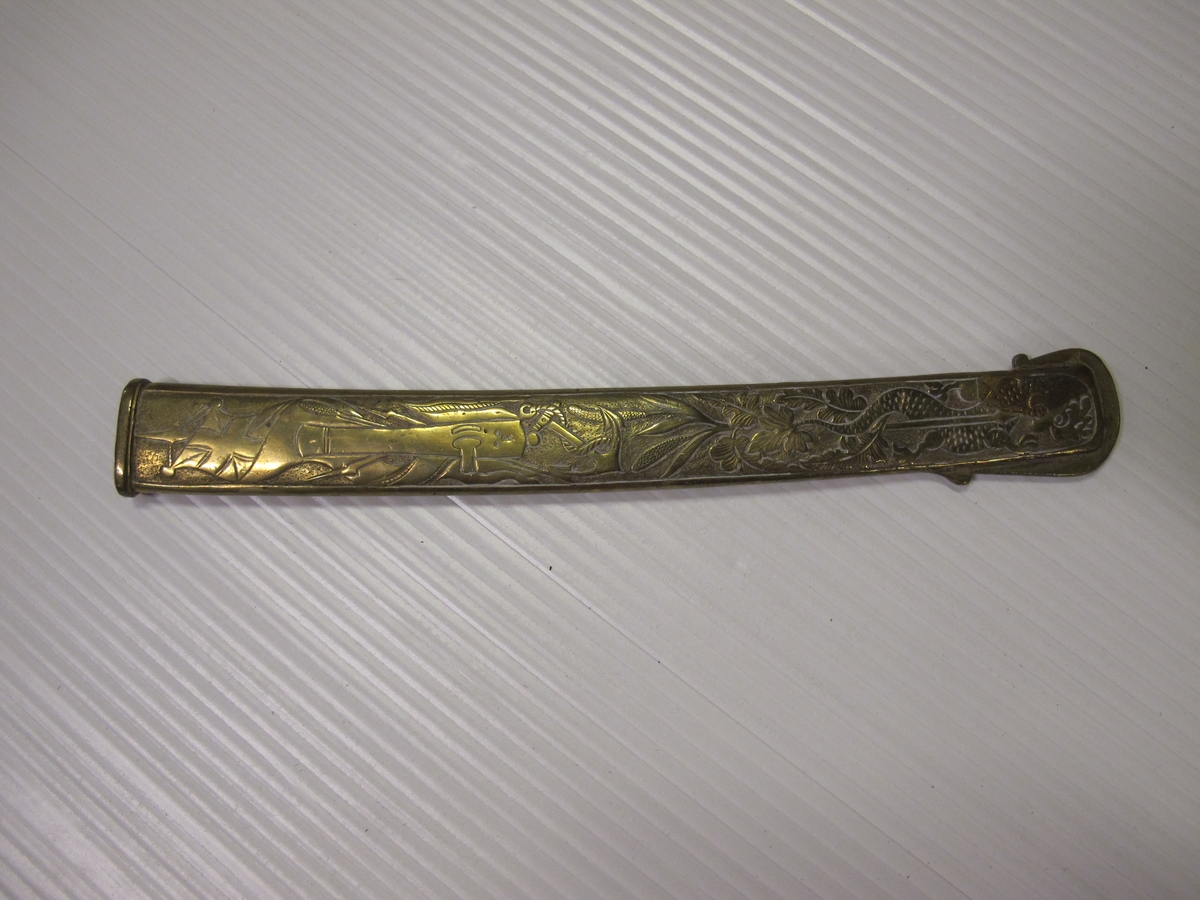Balja til sjöofficerssabel (O 02634.A) av svartlackerat läder med tre stycken förgyllda och cicilerade beslag. Det översta med lilla riksvapnet, ankare, sponton samt ring. Det mellersta med akterspegel och kampanlykta och ring för koppel. Det understa med drake, spjut, bladverk, ankare, kanon, gevär och hillebard samt nya gösen (efter 1844).