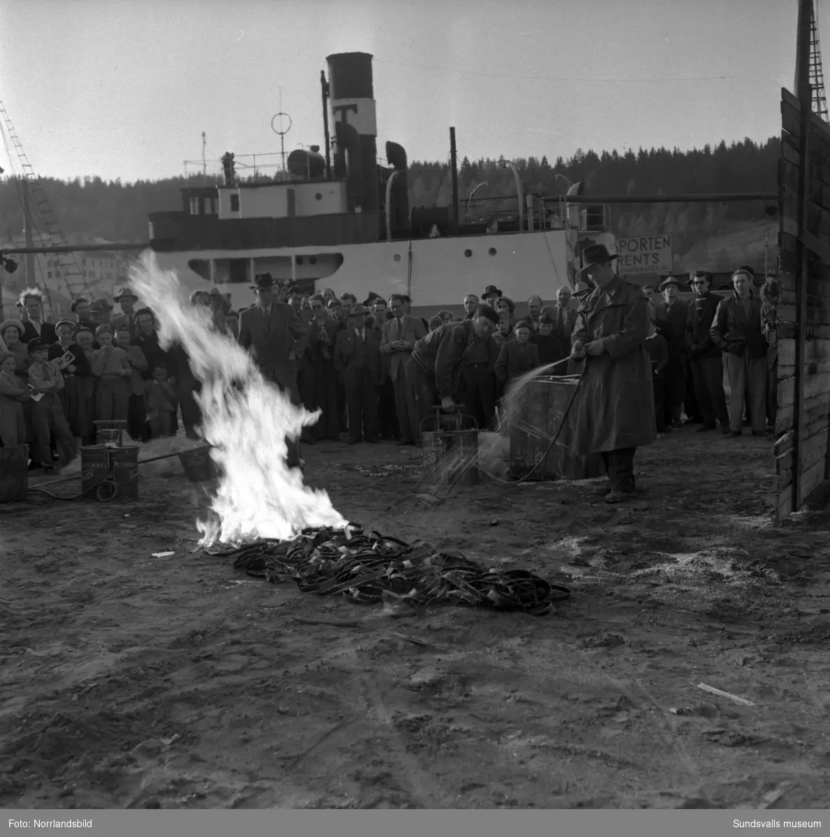 Demonstration av brandskyddsmedel på Finnkajen i hamnen. Gunnar "Marthelli" Lövblad täcks med så kallat Tewisskum och kan sedan stå mitt i ett eldhav.