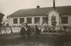 Utklädda ryttare framför åskadare vid en tillställning på Karlberg.