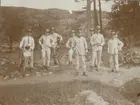 Soldater, varav en del med cykel, uppställda för gruppfoto. I bakgrunden syns en stenig bergsrygg.