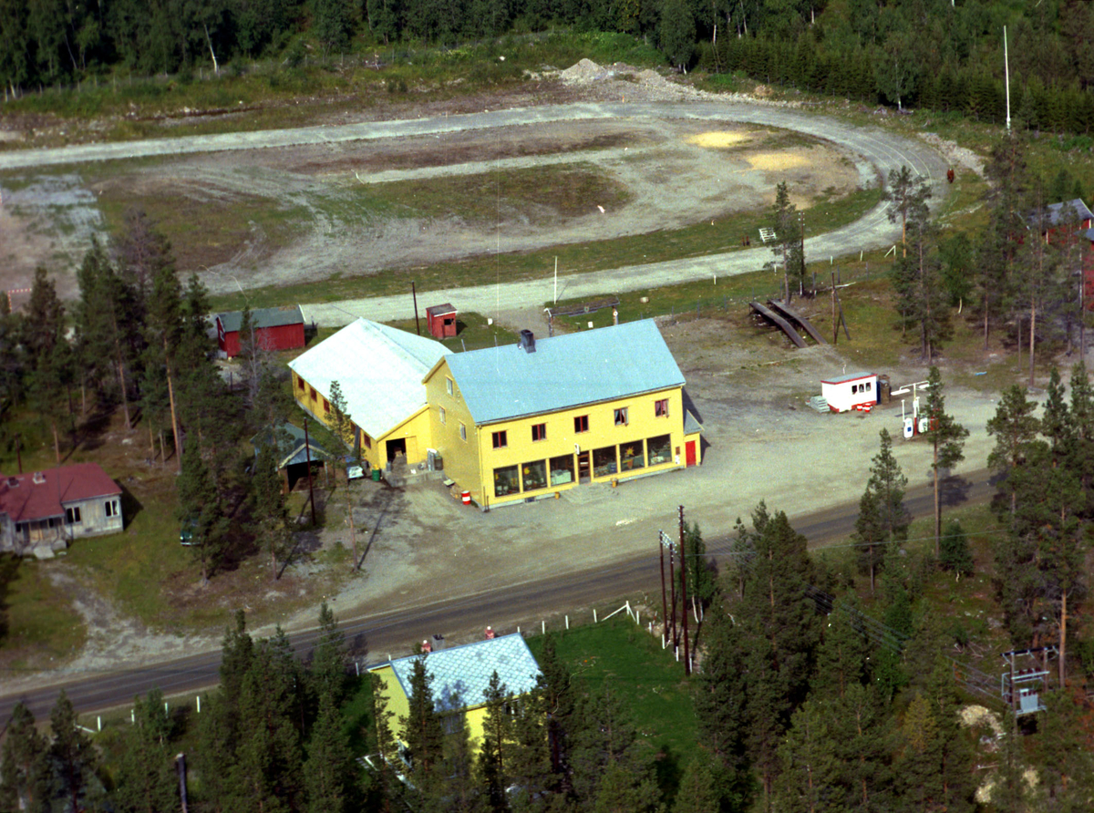 Flyfoto av Holt Samvirkelag i Øverbygd, Målselv 1961. Idrettsbanen til Idrettslaget Jerven i bakgrunnen.