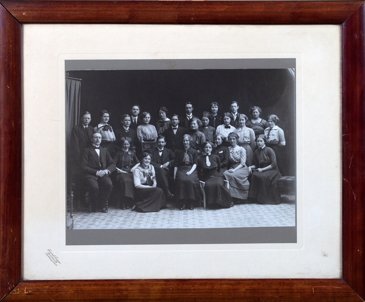 Gruppefoto av studenter til farmasøytisk medhjelpereksamen, syv unge menn og seksten unge damer. I midten Hans Marius Moa som ledet kurset.