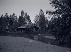 Lillholmen i närheten av Tuna gård. Fotot är taget innan stugan flyttades till Tuna gårds park i början av 1920-talet.