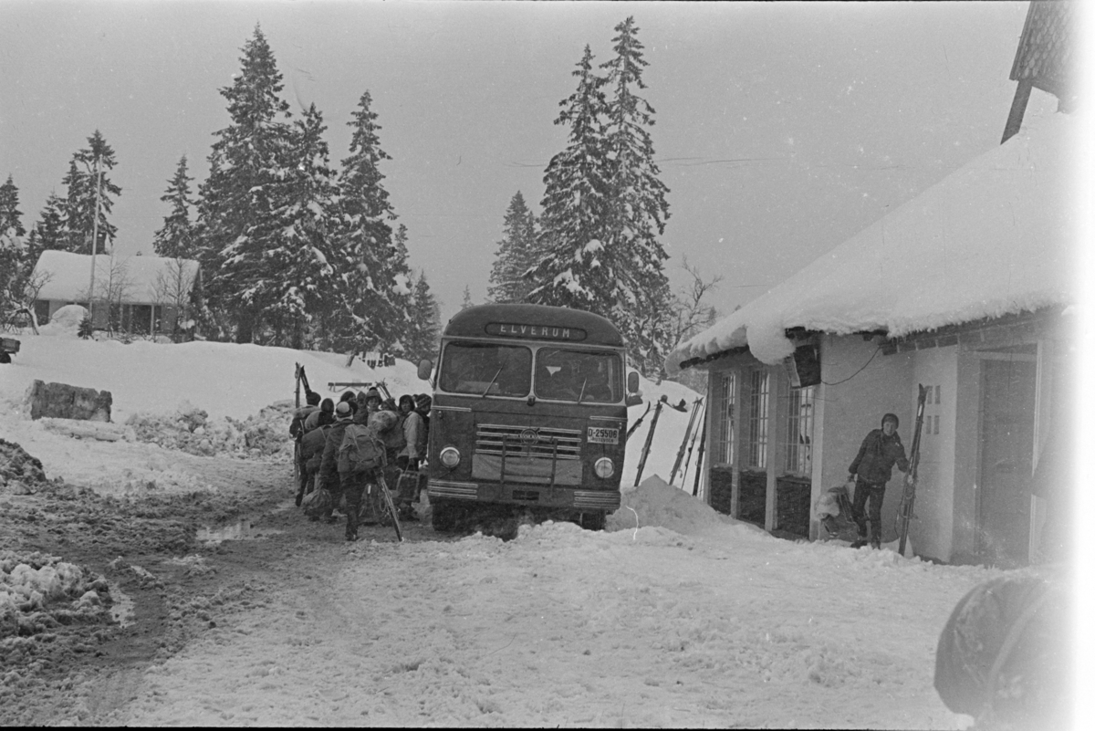 Budor, Løten, parkeringsplass, snøfall, påsketurister, buss,"Elverum" D-25506.
D-25506 var en Volvo B615 personbuss, 1958-modell. Den fikk overflyttet karosseri fra en 1955-modell, et karosseri bygd ved Larvik Karosserifabrikk. Eier av bussen var Elverum Bilruter, et selskap som i 1976 ble overtatt av Norges Statsbaner og enheten ble kalt NSB Elverumsrutene. Bussene til Elverum Bilruter var lakkert røde med gult rundt vinduene.
