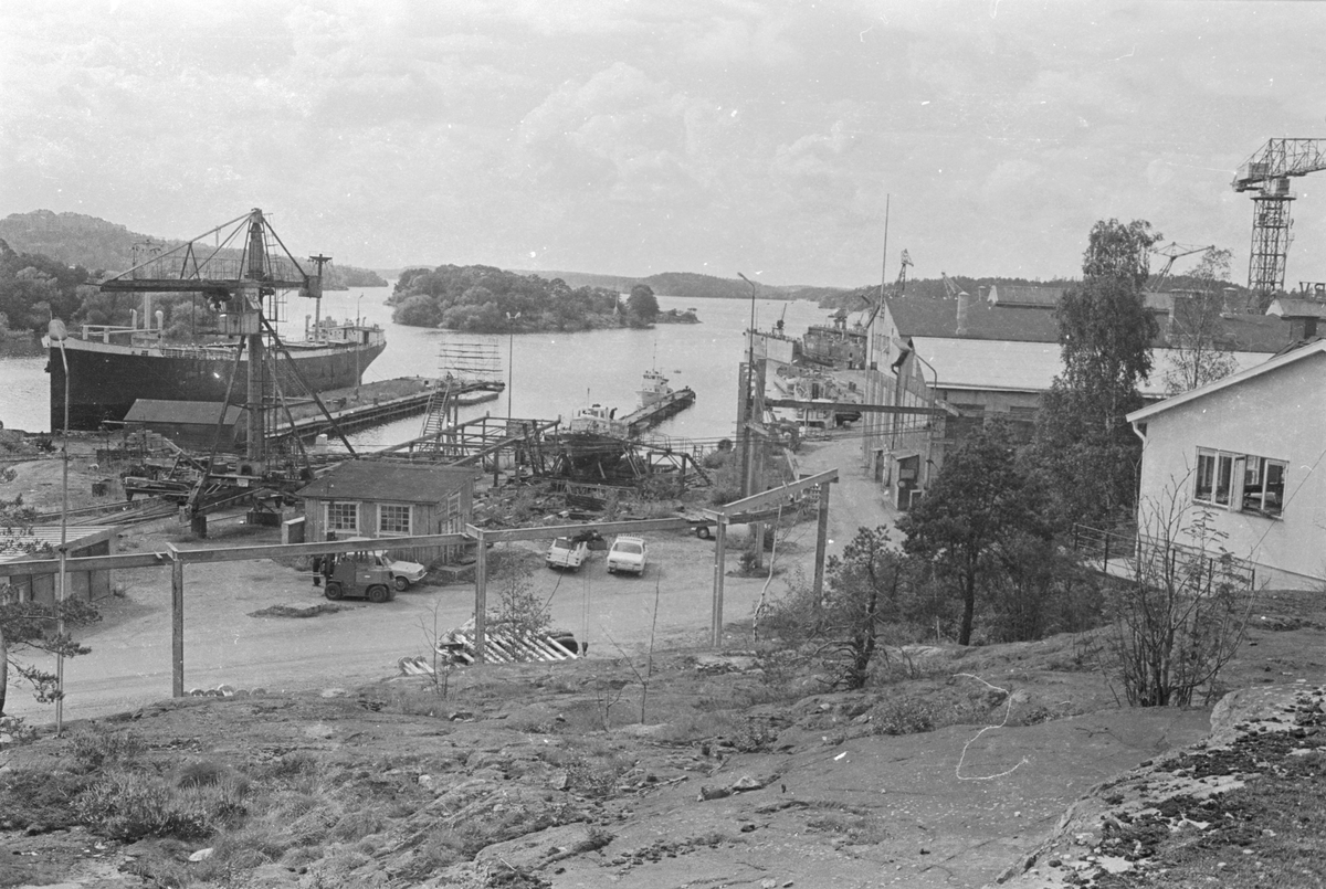 Ekensbergs varv 1970. Varvsområdet sett mot väster. Till v. ses pråmen MONARK (1917, urspr. lastångfartyget MASILIA). I mitten skymtar bl. a. bogserbåten BRAGE (1883, urspr. LINGARÖ) och passagerarångaren EJDERN (1880). Vidare oidentifierad båt på stapelbädd samt pråmar och flytdocka.