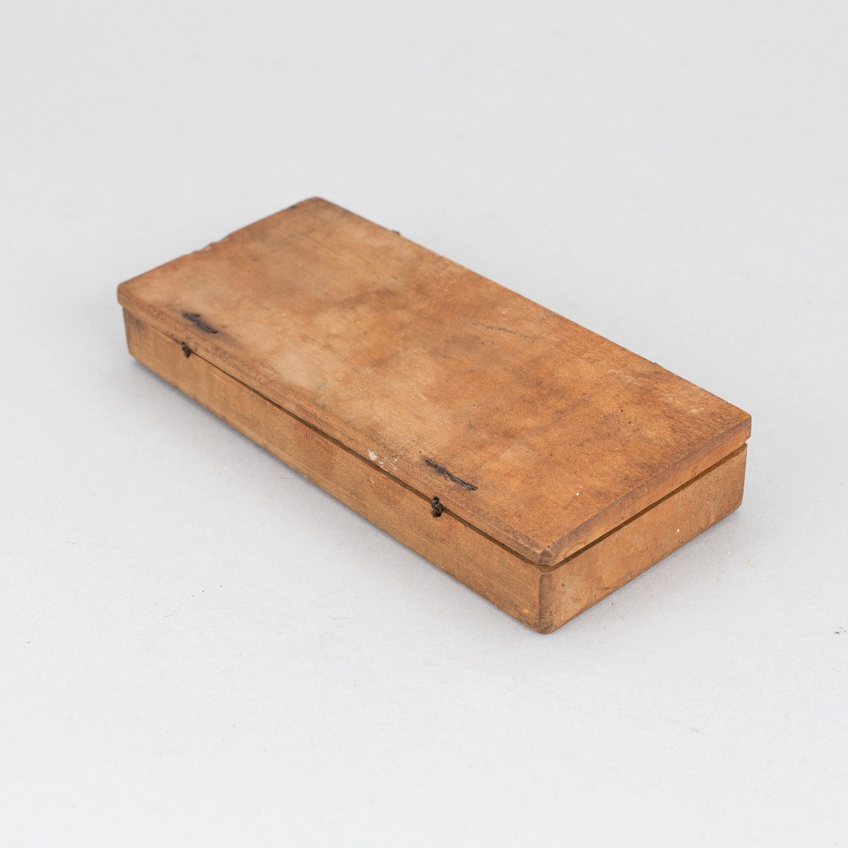 Myntvåg med etui. Vågbalk av järn med spatelformade ändar och åttaformade fästen. Visare av järn med fäste format som ett ankare. Kupiga vågskålar av mässing med inslaget mästarmärke, CM 8 i cirkel. I var skål tre hål för upphängning. Etui av valnötsträ med åtta fack för vikter var av ett med skjutlock.  Fyra kvadratiska stämplade vikter med myntbild för, Doublon, Carolin och Ducat samt mindre punsade balansvikter i skala 4 - 5. I övre delen av etuiet utskuret urtag för balansvåg. I etuiets lock en stålpinne för att lyfta vikterna ur sina fack. I lock stämpel med text Recht abgesogen (= riktigt avpassat) och annan otydd text på tyska. 10 delar totalt.