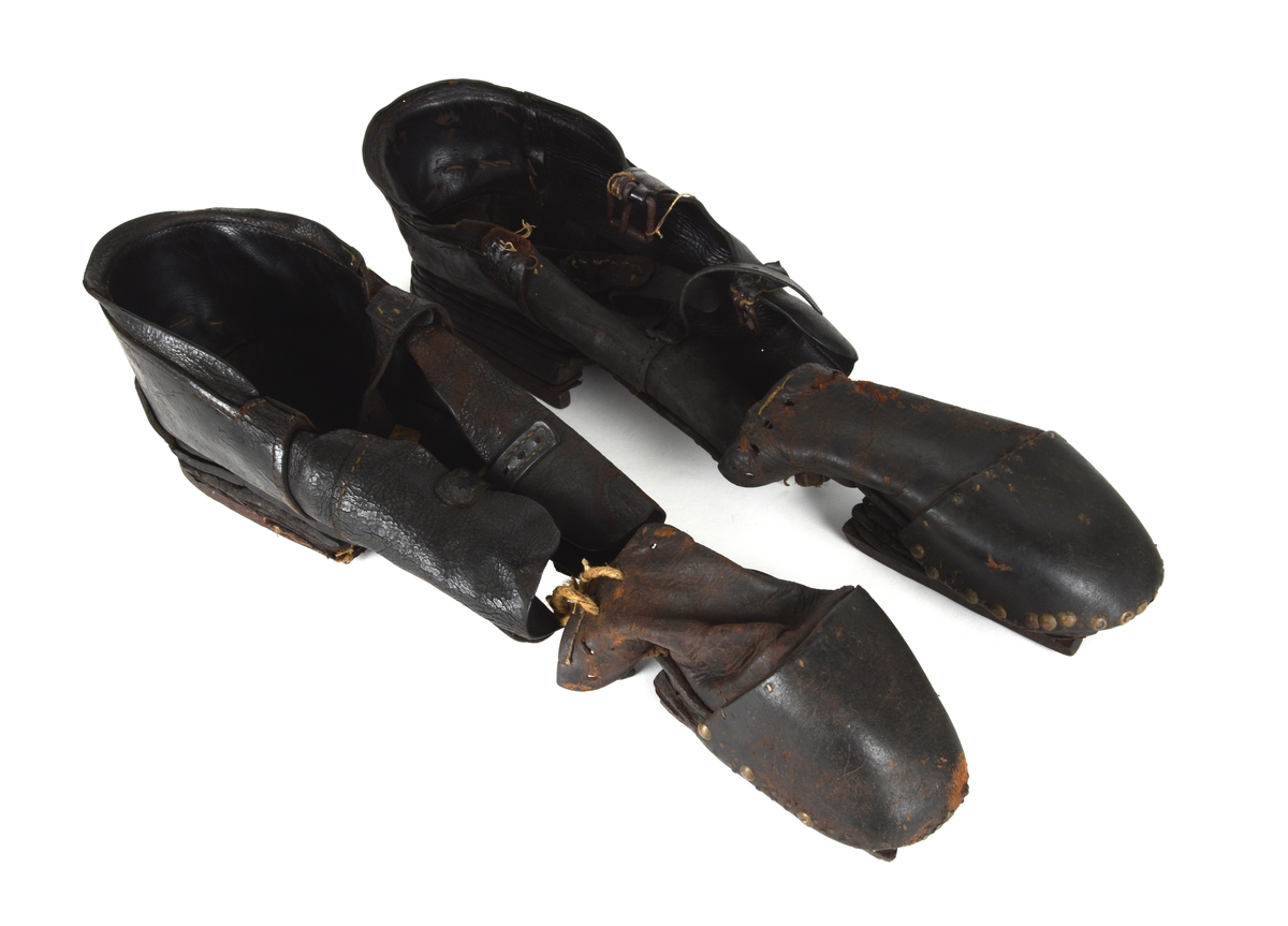 Et par spesialsko med lærreimer som festes til knærne. De består av to deler til kne/legg og to deler til fot/tær. Skoene er laget til en handikappet mann som gikk på knærne.

Leggskoene har jern på undersiden, festet med 6 hesteskosømmer. To spenner med reimer for festing til legg.

Tåskoene har to jern på undersiden, på den ene festet med 7 hesteskosømmer. Den andre har 6 hesteskosømmer og tau for snøring.