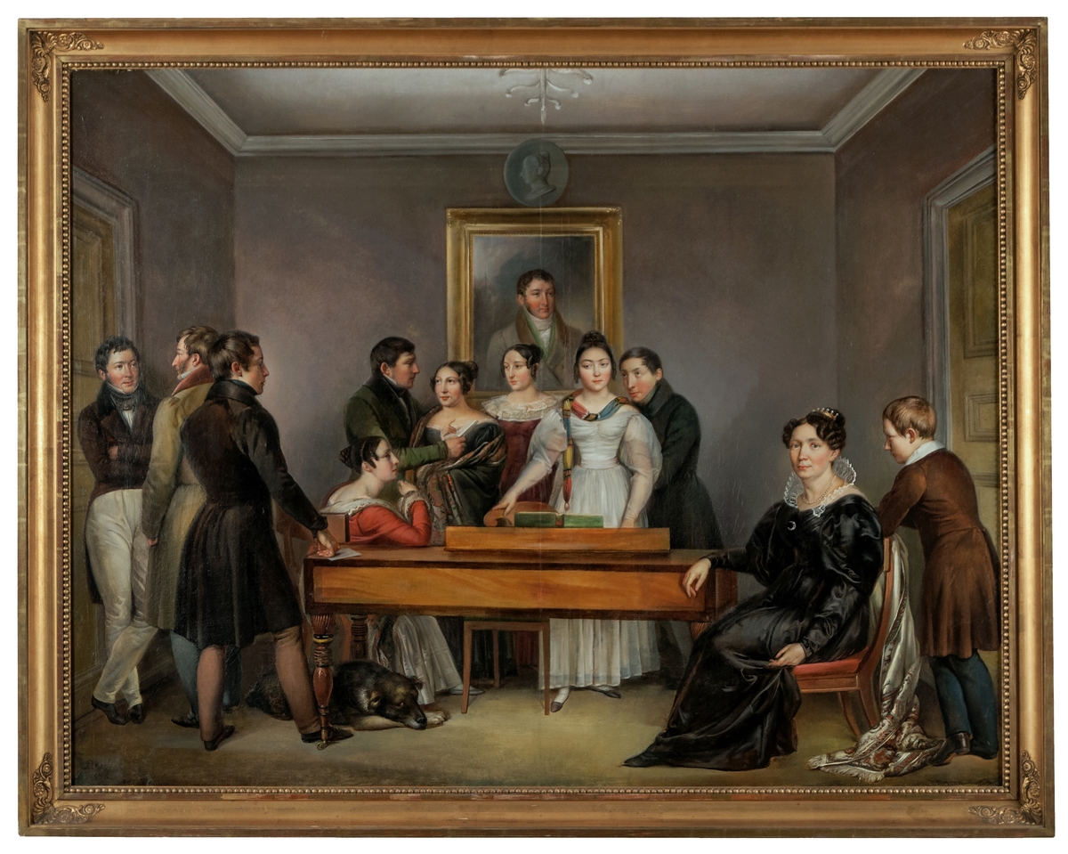 Oljemålning föreställande familjen Garberg i Gävle. Kring spinetten i en salong är medlemmar av familjen Garberg samlade: fru Carin Garberg (född Sehlberg) sittande till höger, hennes avlidna make Anders Garberg syns på porträttmålningen i bakgrunden, och deras tio barn.