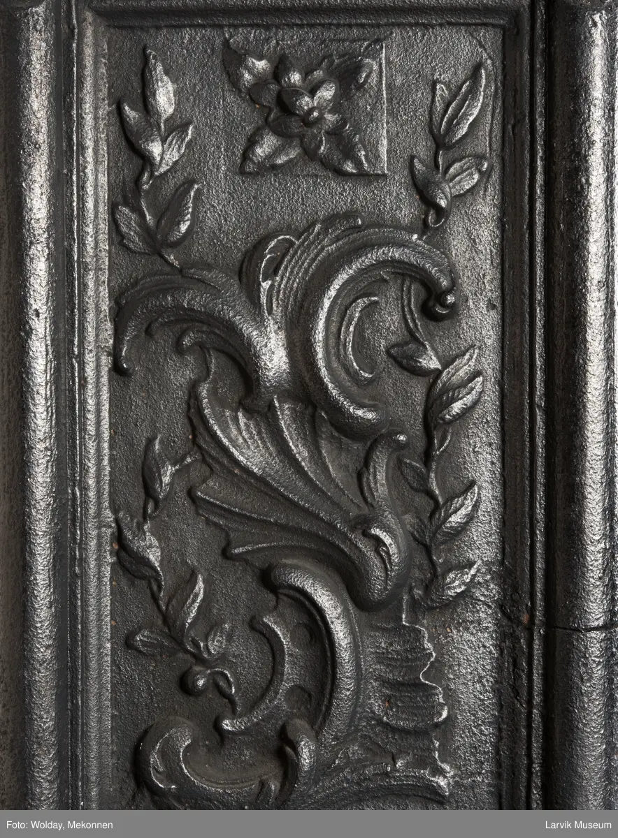 Ovn i  2 etasjer. 
Rokokko, jfr. nr 411 i Norsk Jernskulptur b II 
1. etasje langside: Mars sitter på en kanon med sverd i høyre hånd. Riflet bunn.
1 etasje kortside: Øverst: Rokokko-ornament, nederst: Grevekrone monogram. FL og 1756 
nederst: ovnsdør 2 hengsler ovalt askebrett med profilert kant.
2.etasje langside: Fyldig rokokko-ornament. med blomster. Uregelemessig portalåpning. 
2. etasje kortside: Rokokko-ornament, 
Ovnen har sungne ben m/dyreføtter