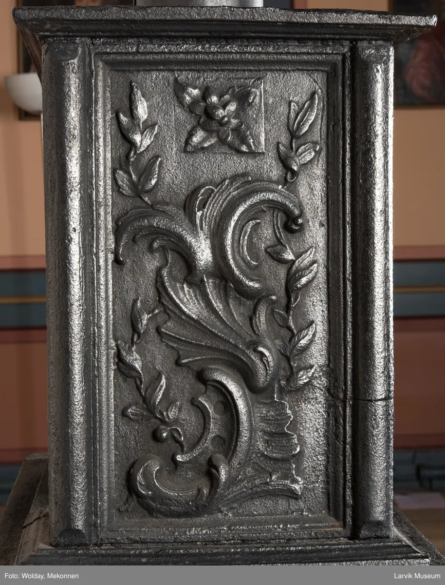 Ovn i  2 etasjer. 
Rokokko, jfr. nr 411 i Norsk Jernskulptur b II 
1. etasje langside: Mars sitter på en kanon med sverd i høyre hånd. Riflet bunn.
1 etasje kortside: Øverst: Rokokko-ornament, nederst: Grevekrone monogram. FL og 1756 
nederst: ovnsdør 2 hengsler ovalt askebrett med profilert kant.
2.etasje langside: Fyldig rokokko-ornament. med blomster. Uregelemessig portalåpning. 
2. etasje kortside: Rokokko-ornament, 
Ovnen har sungne ben m/dyreføtter