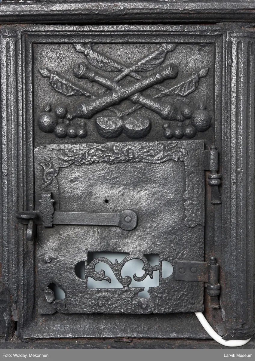 1. etasje langside: Chr. VII's byste, rosetter, meander ramme.
1. etasje kortside: Krigerske emblemer over Fritzøe Wærk 1774, under krigerske emblemer, dør med gjennombrudd blomstermønster
2. etasje langside: Rundbuet åpning med kanellert ramme, øverst kroningsregaliene, gitret bunn.
2.etasje kortside: kronet C7 på gitret bunn jfr. nr 420 i Norsk Jernskulptur II.