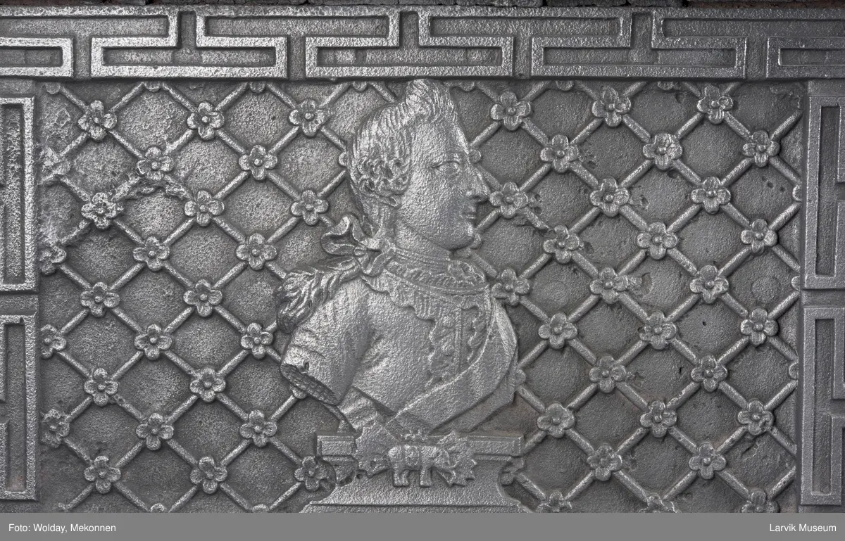 1. etasje langside: Chr. VII's byste, rosetter, meander ramme.
1. etasje kortside: Krigerske emblemer over Fritzøe Wærk 1774, under krigerske emblemer, dør med gjennombrudd blomstermønster
2. etasje langside: Rundbuet åpning med kanellert ramme, øverst kroningsregaliene, gitret bunn.
2.etasje kortside: kronet C7 på gitret bunn jfr. nr 420 i Norsk Jernskulptur II.