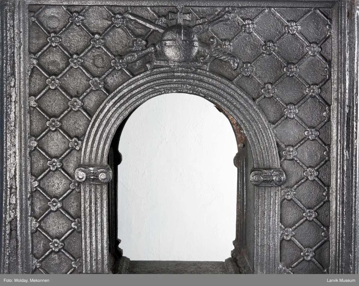 1. etasje langside: Chr. VII's byste, rosetter, meander ramme.
1. etasje kortside: Krigerske emblemer over Fritzøe Wærk 1774, under krigerske emblemer, dør med gjennombrudd blomstermønster
2. etasje langside: Rundbuet åpning med kanellert ramme, øverst kroningsregaliene, gitret bunn.
2.etasje kortside: kronet C7 på gitret bunn jfr. nr 420 i Norsk Jernskulptur II.