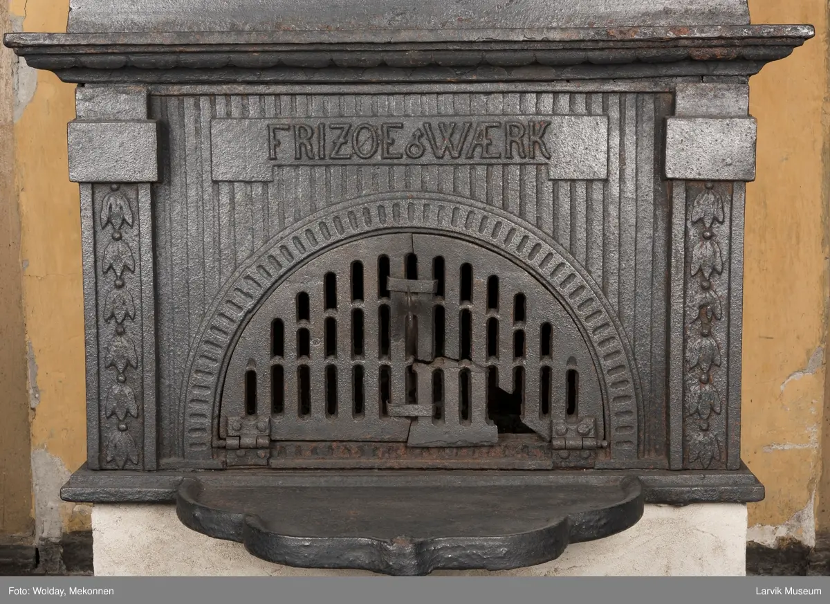 Ovn med avtrappet topp, ovalt, bølget askebrett. 
1. etasje langside: halvsirkelformet. Døren er hengslet i underkant. Over denne på plate står det Fritzøe Wærk. Riflet bunn, lisener med bladverk ved hjørnene. 1. etsje kortside: Rosett, riflet bunn, 
2. etasje langside: Rundbuet åpning, lister til 4 etasjeplater. Over åpning 2 overflødighetshorn, under palmett i riflet ramme. kannelserte pilastre i hjørnene. 2. etasjekortside: Rosett på riflet bunn, bølgemeander.