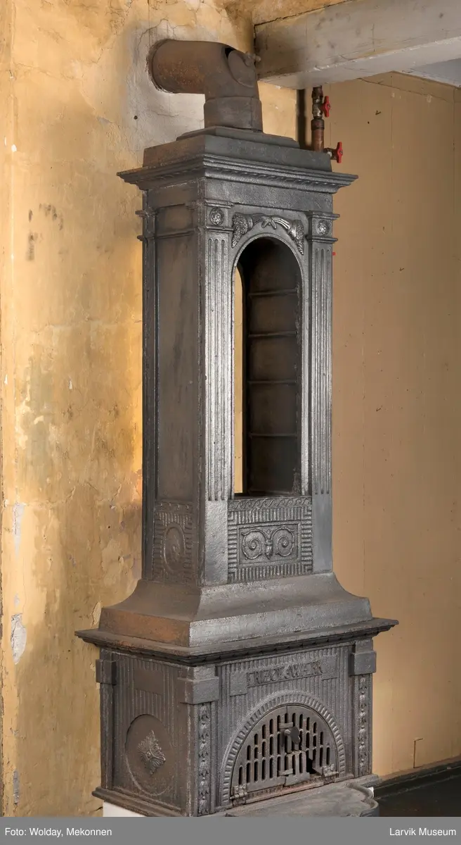 Ovn med avtrappet topp, ovalt, bølget askebrett. 
1. etasje langside: halvsirkelformet. Døren er hengslet i underkant. Over denne på plate står det Fritzøe Wærk. Riflet bunn, lisener med bladverk ved hjørnene. 1. etsje kortside: Rosett, riflet bunn, 
2. etasje langside: Rundbuet åpning, lister til 4 etasjeplater. Over åpning 2 overflødighetshorn, under palmett i riflet ramme. kannelserte pilastre i hjørnene. 2. etasjekortside: Rosett på riflet bunn, bølgemeander.