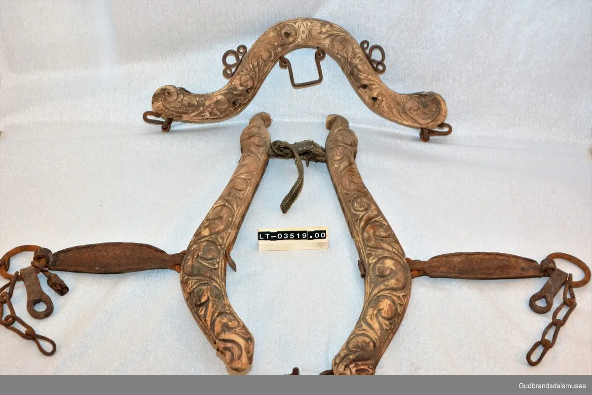 Et par bogtrær med drått og orering i jern. Høvre med ringer av jern for tømmer, to fester av jern for oppholdsreimer, jernbøyle for ryggreim.
DEKOR. Sammenhengende akantusranke i barokkstil med mye bladverk. Den forenklede akantusskurden er et stiltrekk som hører hjemme på slutten av 1700-tallet, begynnelsen på 1800-tallet. (Se også LBY0150b; LBY0151a, b). Inskripsjonen på dråtten P J S E 1827 står antakelig for Peder Johannessen Enstad, f. 1798, d. 1828, gardbruker på Sørpå Enstad fra 1820. Årstallet 1827 antas å være produksjonsåret for høvret og bogtreet.
BRUK. Høvre og bogtre hører sammen. De utgjør de primære festeanordningene for seletøyet og medvirker til å fordele trekkbelastningen på en hensiktsmessig måte. Høvren er plassert fremme over ryggen på hesten. Den har huller eller ringer som tømmene blir ført igjennom og er i tillegg festepunkt for rygg- og bære-/oppholdsreimer. Bærereimene går videre nedover og er koplet til draget/skåken.
Bogtrærne er festet til hverandre over nakken med en nakkereim og rundt brystet med en brystreim. Midt på treet er det hull for feste av dråtten. Dråtten, en 6-7 cm. bred, stiv lærreim, blir i motsatt ende festet til draget/skåken.