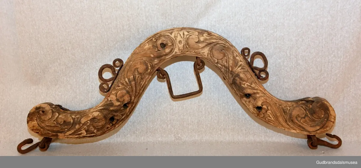 Et par bogtrær med drått og orering i jern. Høvre med ringer av jern for tømmer, to fester av jern for oppholdsreimer, jernbøyle for ryggreim.
DEKOR. Sammenhengende akantusranke i barokkstil med mye bladverk. Den forenklede akantusskurden er et stiltrekk som hører hjemme på slutten av 1700-tallet, begynnelsen på 1800-tallet. (Se også LBY0150b; LBY0151a, b). Inskripsjonen på dråtten P J S E 1827 står antakelig for Peder Johannessen Enstad, f. 1798, d. 1828, gardbruker på Sørpå Enstad fra 1820. Årstallet 1827 antas å være produksjonsåret for høvret og bogtreet.
BRUK. Høvre og bogtre hører sammen. De utgjør de primære festeanordningene for seletøyet og medvirker til å fordele trekkbelastningen på en hensiktsmessig måte. Høvren er plassert fremme over ryggen på hesten. Den har huller eller ringer som tømmene blir ført igjennom og er i tillegg festepunkt for rygg- og bære-/oppholdsreimer. Bærereimene går videre nedover og er koplet til draget/skåken.
Bogtrærne er festet til hverandre over nakken med en nakkereim og rundt brystet med en brystreim. Midt på treet er det hull for feste av dråtten. Dråtten, en 6-7 cm. bred, stiv lærreim, blir i motsatt ende festet til draget/skåken.