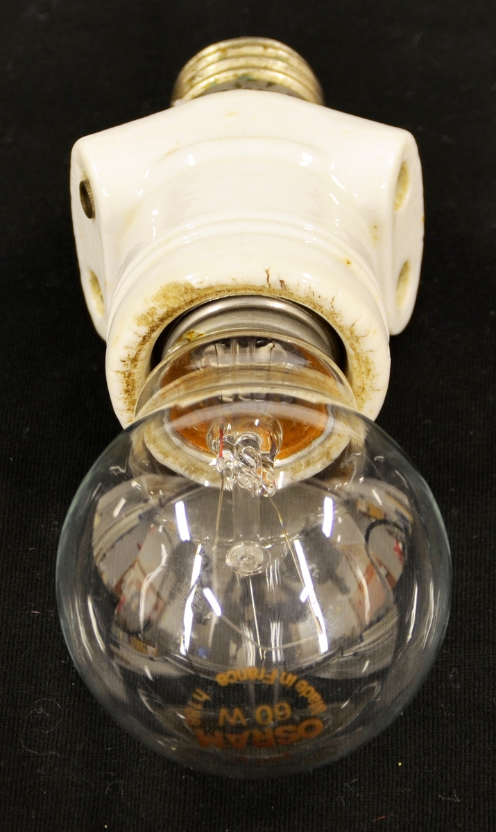 Hol i eine enda med gjenger i metall inni. På kvar side er det to hol. I andre enden metallgjenger. Porselen utanpå med to spor nedst mot pære.