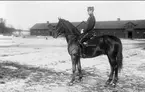 Strömsholmskursen 1916. Ridning på Strömsholm på Stallplan mellan lilla ridhuset (till vänster), officersstallet (till höger), hingstridhuset och hingststallet.