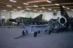 Flygplan J 35 nummer 13 och 28 står i en hangar på F 3 Malmen, våren 1973. Underhåll pågår.