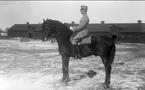 Strömsholmskursen 1916. Ridning på Strömsholm på Stallplan mellan lilla ridhuset (till vänster) officersstallet (till höger), hingstridhuset och hingststallet.