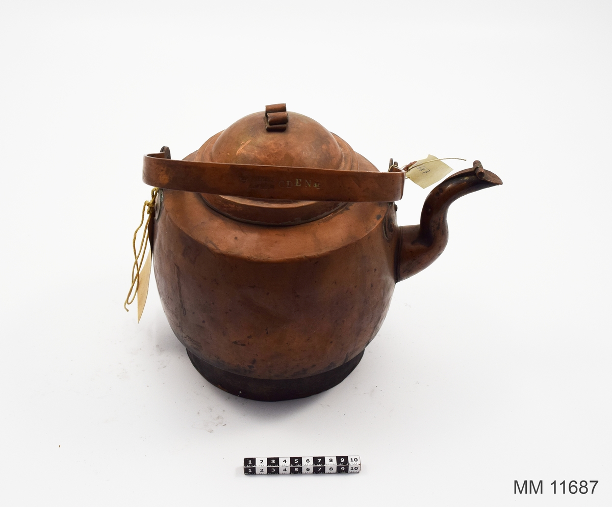 Kaffekittel av koppar. från början av 1900-talet. Försedd med lock, handtag och pip samt nedtill en avsats för spisringarna. Märkning: Oden samt två kronstämplar. Även tillverkarstämpel som lyder: J och C G Bolinder.