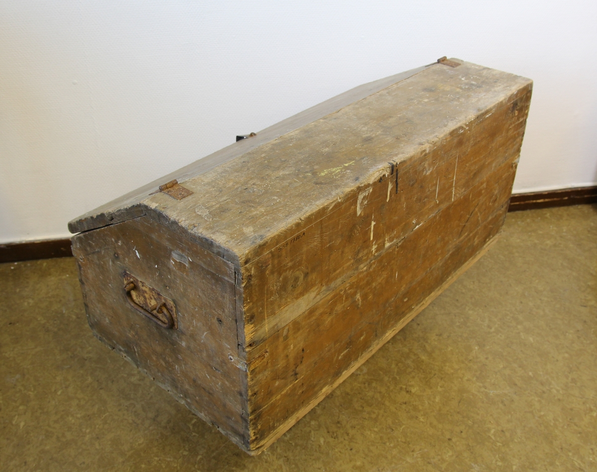 Verktøykiste av tre. Skråstilt lokk. Skuff øverst i rommet. Handtak på sidene.